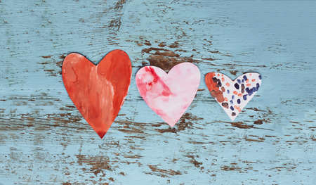 Paper hearts on shabby wooden background.