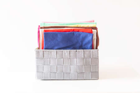 Folded colorful clothes in the box. Home organizing. Domestic vertical storage.