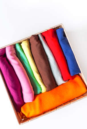 Folded colorful clothes in the box. Home organizing. Domestic vertical storage.
