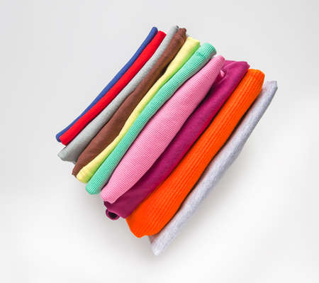 Folded colorful clothes in the box. Home organizing. Domestic vertical storage.