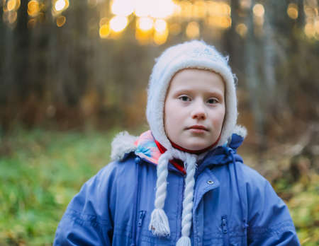 Little girl in autumn forest.