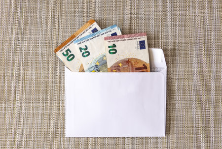 Euro money banknotes in the white paper envelope on a light background close up.の写真素材
