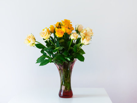 Beautiful bright yellow rose flowers. Bouquet in retro style glass vase.の写真素材