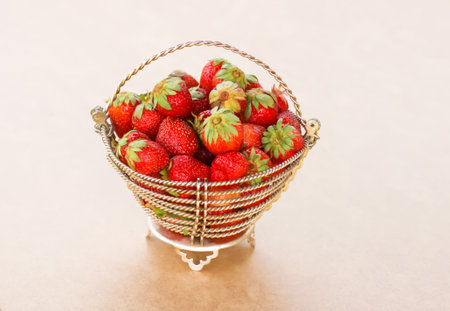 Ripe red strawberry in the wicker basket on the linen tablecloth.の写真素材