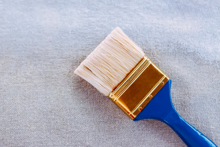 Synthetic paint brush and primer on canvas surface.の写真素材