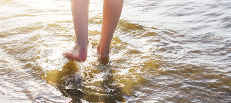 Child's bare feet walking at a beach.の写真素材