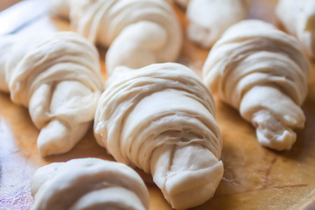 Raw croissant rolls in baking process.の写真素材