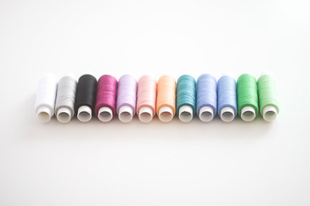 Many colorful sewing threads on light background.の写真素材