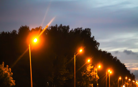 A row of street lights against the night sky.