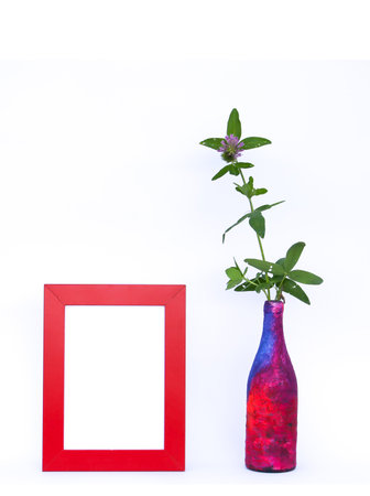 Blank picture frame and a flower in motley vase.の写真素材