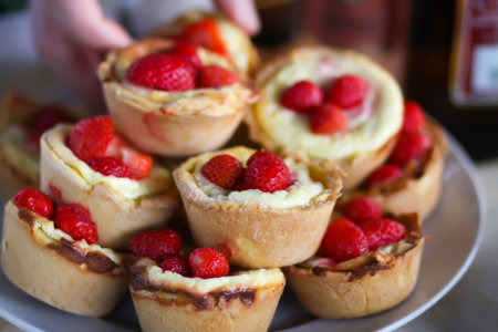Fresh strawberry-topped cupcakes on rustic table.の写真素材