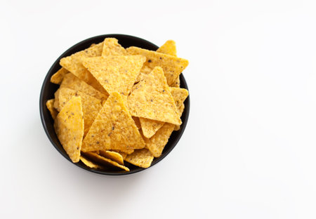 Crispy corn tortilla chips stacked on a plate. A simple snack full of texture and flavor.の写真素材