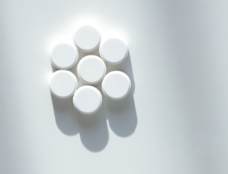 Various white pills on white background. Expresses clarity, vitality, and self-care.の写真素材