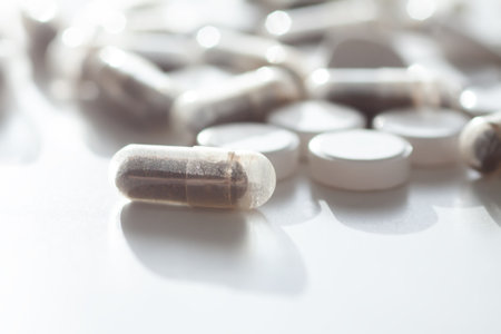 Assorted capsules and tablets under soft light. Evokes modern wellness and healthcare aesthetics.の写真素材