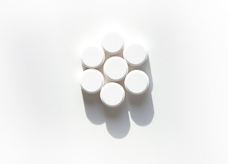 Various white pills on white background. Expresses clarity, vitality, and self-care.の写真素材