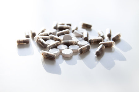Capsules and tablets on neutral surface. Symbol of balance, immunity, and wellness culture.の写真素材