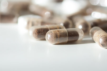 Assorted capsules and tablets under soft light. Evokes modern wellness and healthcare aesthetics.の写真素材