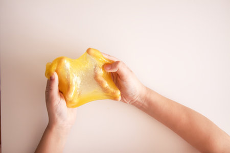 Close-up of children's hands covered in bright slime. Reflects art, craft, and free play.の写真素材