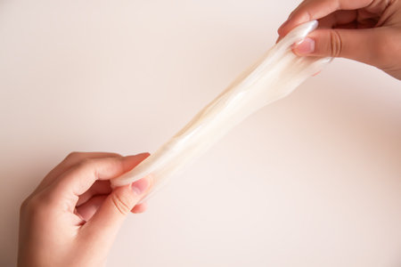 Hands stretching colorful slime. Creativity, fun, and sensory exploration.の写真素材