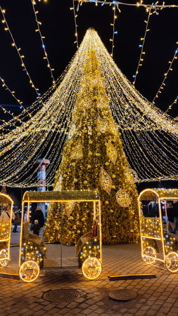 A glowing Christmas tree decorates urban rest center. The scene evokes warmth, community, and magical winter nights.の写真素材