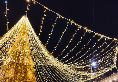 A glowing Christmas tree decorates urban rest center. The scene evokes warmth, community, and magical winter nights.の写真素材