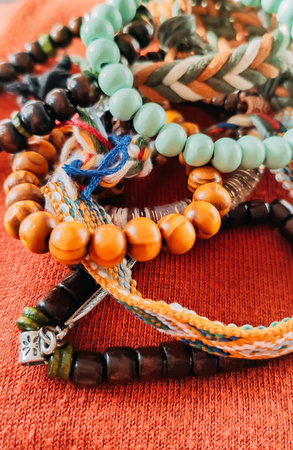 Handcrafted bracelets with wooden elements sit on a soft textile. It suggests authenticity, warmth, and bohemian aesthetics.の写真素材