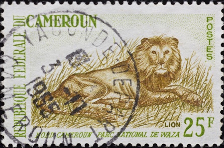 CAMEROON - CIRCA 1965: A stamp printed in Cameroon,shows a rural scene with a Lion,circa 1965.のeditorial素材