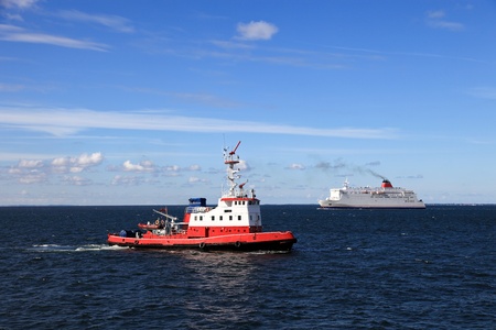 Fireboat on the background of a cruise ship on the seas.の写真素材