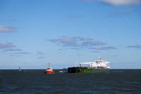 Escorting tanker by red tugs.の写真素材