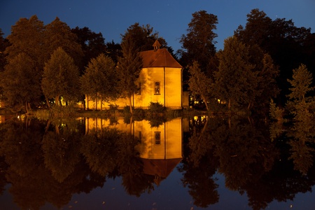 Church on the water at night in Zwierzyniec, Poland.の写真素材
