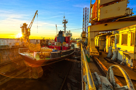 Ship in dry dock at sunrise - shipyards in Gdansk, Poland 