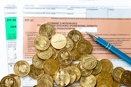 Filling in polish individual income tax form PIT with money and pen  