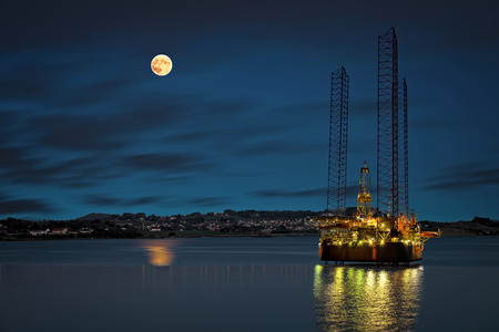 Oil platform at night time and the moon  の写真素材