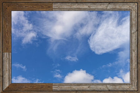 Old wood window with blue sky and clouds.の写真素材
