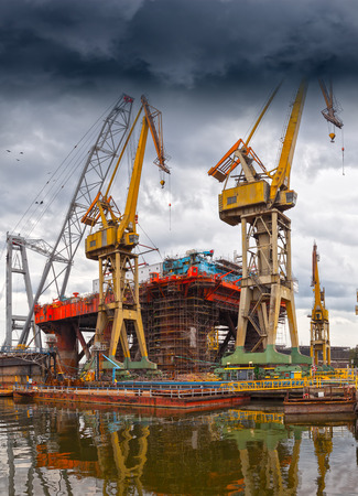 Big industrial crane on a dramatic sky background.の写真素材