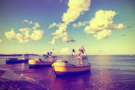 Fishing boats is moored in beach. Vintage toned photo.