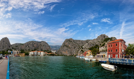 The town of Omis looking over the river Cetina, boats and tourists walking in the distance, on July 23, 2014 in Omis, Croatia.のeditorial素材