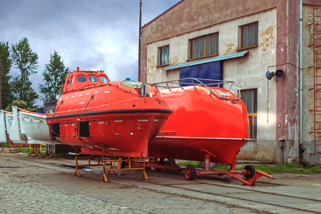 A lifeboat at the shore in shipyard.の写真素材