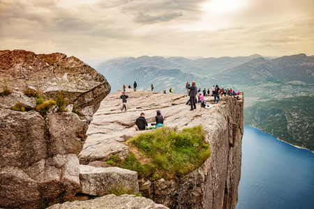 Group of tourists looking over the edge of Pulpit Rock on Lysefjorden, on July 12, 2015 in Forsand, Norway.のeditorial素材