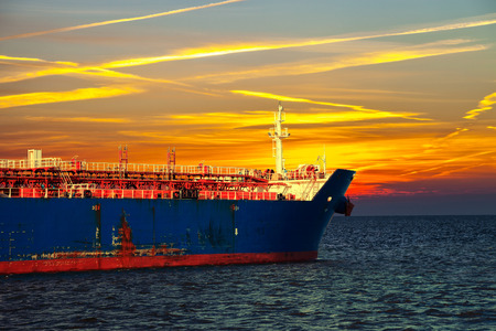 Tanker ship on sea in the rays of the setting sun.の写真素材