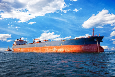 Tug boat towing a tanker ship at sea.の写真素材