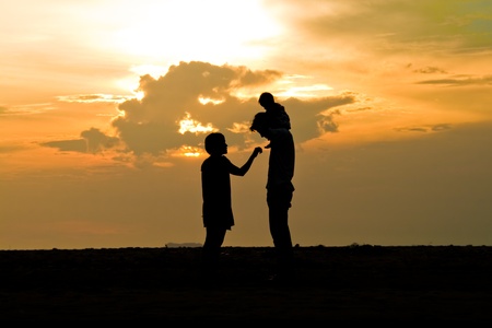 the family promenade on the beach (silhouette)の写真素材