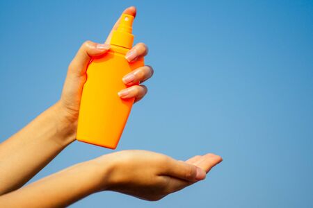 Bottle of sunscreen lotion suncream packaging on the sandy beach sea sky background copy space.oil spa spf summer vacation on tropical paradise copyspace.の写真素材