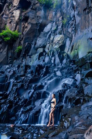 Girl in black swimsuit at amazing Waterfall india wildernest dudhsagarの写真素材