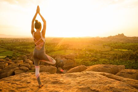 Yoga in Hampi temple copyspase at sunset.travel vacation copy spase lady with stylish jumpsuitの写真素材
