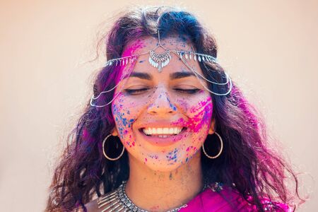 Holi Festival Of Colours. Portrait of happy indian girl in traditional hindu sari on holi color . india woman silver jewelry with powder paint on dress ,colorful pink and blue hair in Goa Keralaの写真素材