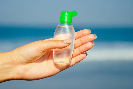 antiseptic in the hands of a woman on the beach