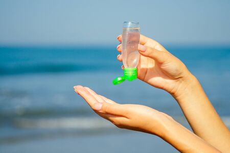 antiseptic in the hands of a woman on the beach