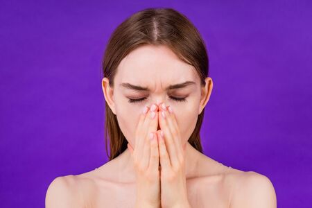 portrait of a beautiful stress woman headache on purple background in studio