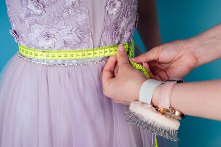 seamstress tailor dressmaker designer wedding dress measures the volume of the clients body...